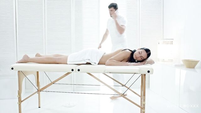 Leanne Lace whiteboxxx oily solo next to a folding massage bed